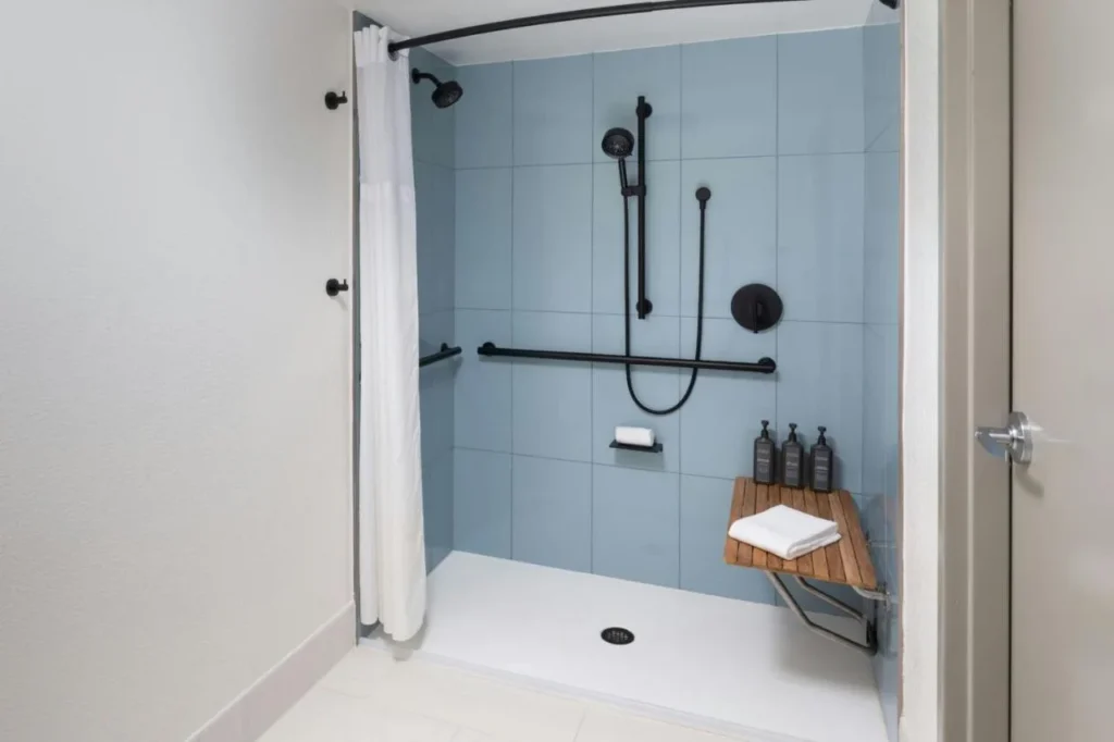 Ducha plegable con barras de apoyo, ducha de mano y banco de madera plegable en Sheraton Lake Buena Vista