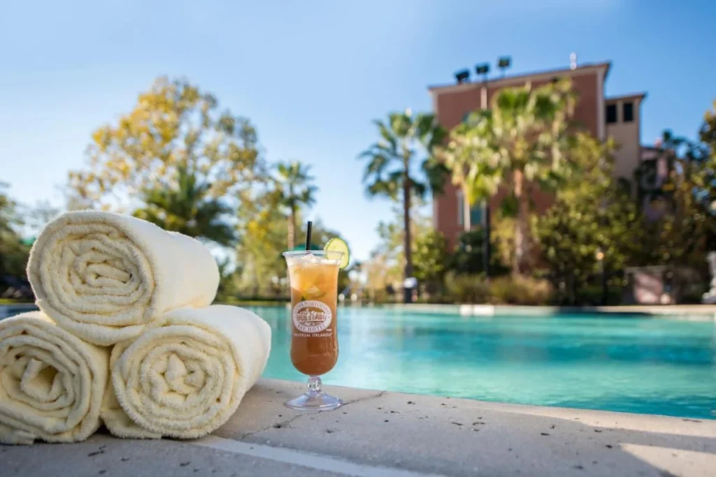 Toallas enrolladas y una bebida helada junto a la piscina en Loews Portofino Bay Hotel