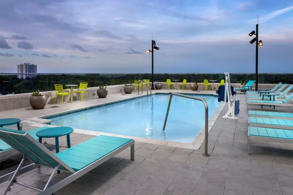 Rooftop pool with turquoise loungers at Home2 Suites by Hilton Orlando Downtown