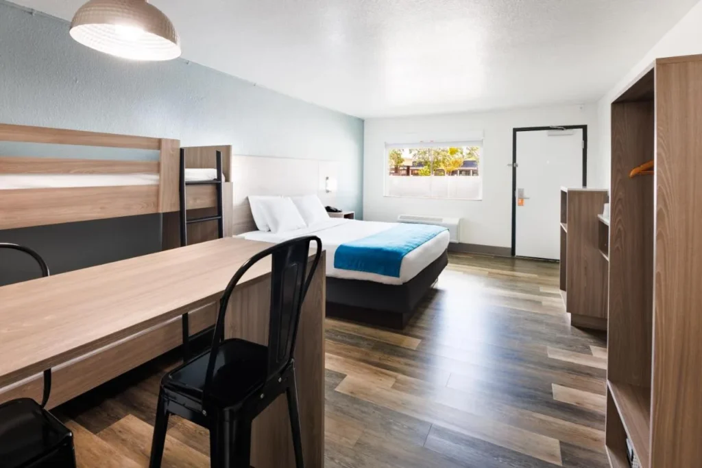 Room with a bunk bed, a second bed and a long desk at CoCo Key Orlando