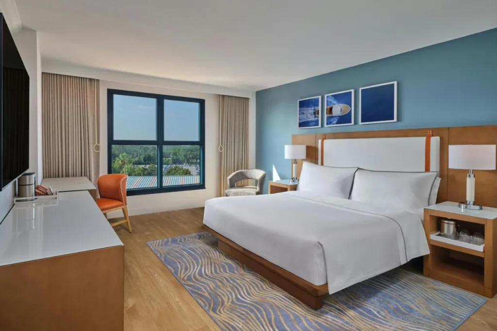 Room with one large bed and a blue accent wall at the Walt Disney World Swan