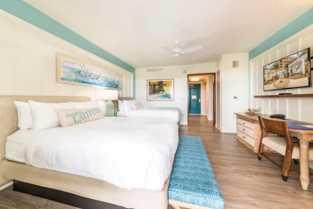 Habitaci&oacute;n con dos camas, un banco azul y un escritorio en Margaritaville Resort Orlando