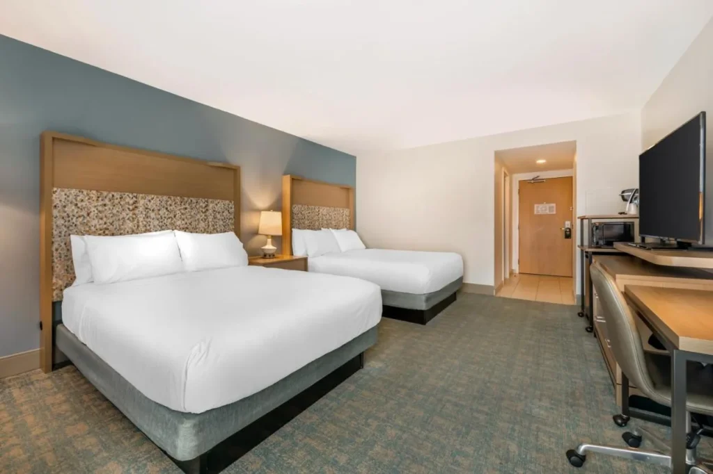 Room with two beds, a desk and a TV at Holiday Inn Orlando Disney Springs Area