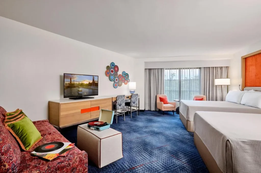 Habitaci&oacute;n con dos camas, un sof&aacute; estampado y un tocadiscos en el Hard Rock Hotel