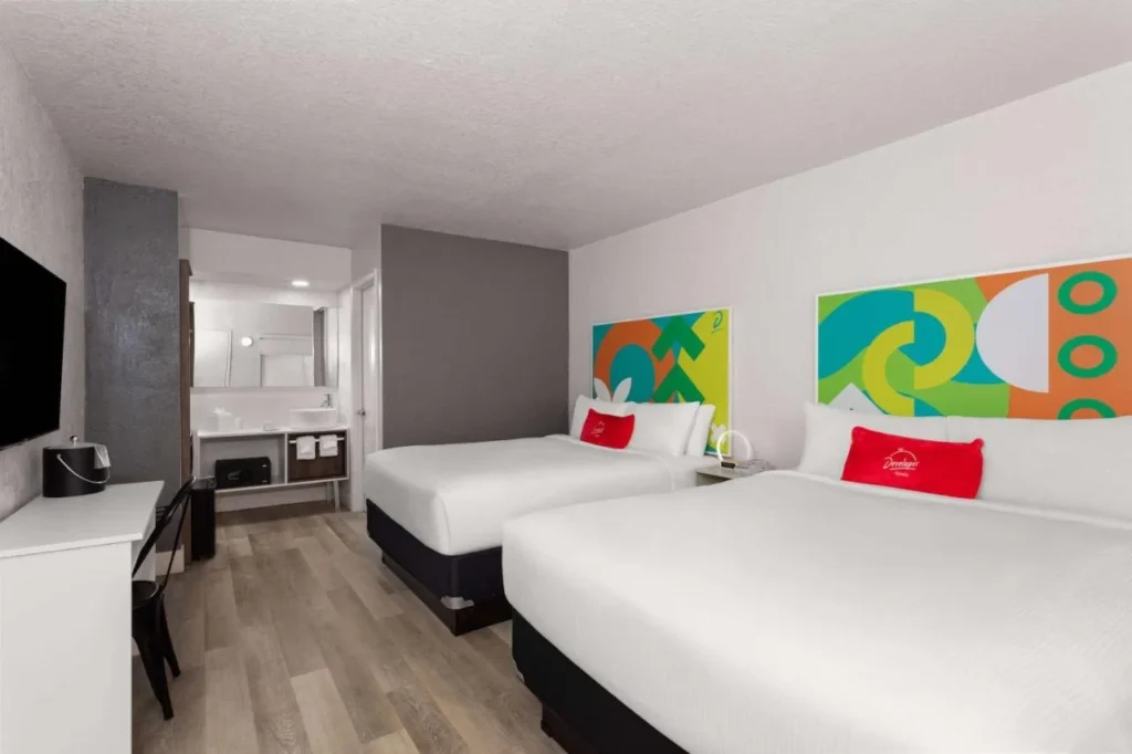 Habitaci&oacute;n con dos camas y colorido arte de cabecera en el Travelodge Orlando Lake Buena Vista South
