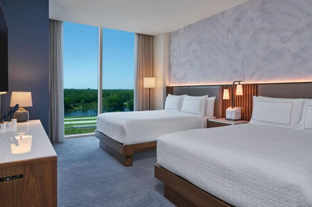 Room with two beds and floor-to-ceiling windows at the Walt Disney World Swan Reserve