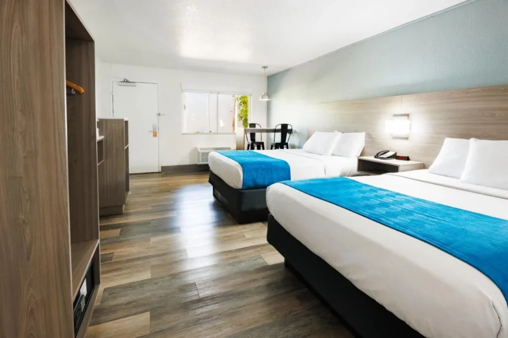 Room with two beds, blue runners and wood-look floor at CoCo Key Hotel and Water Resort