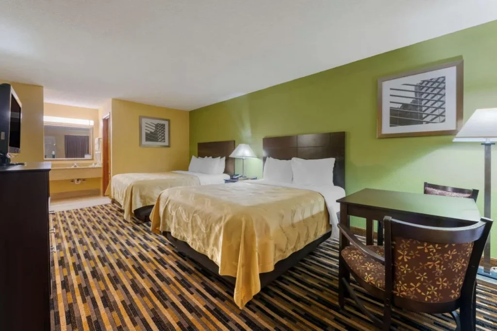 Room with two beds, desk and vanity area at Quality Inn & Suites Mt Dora North