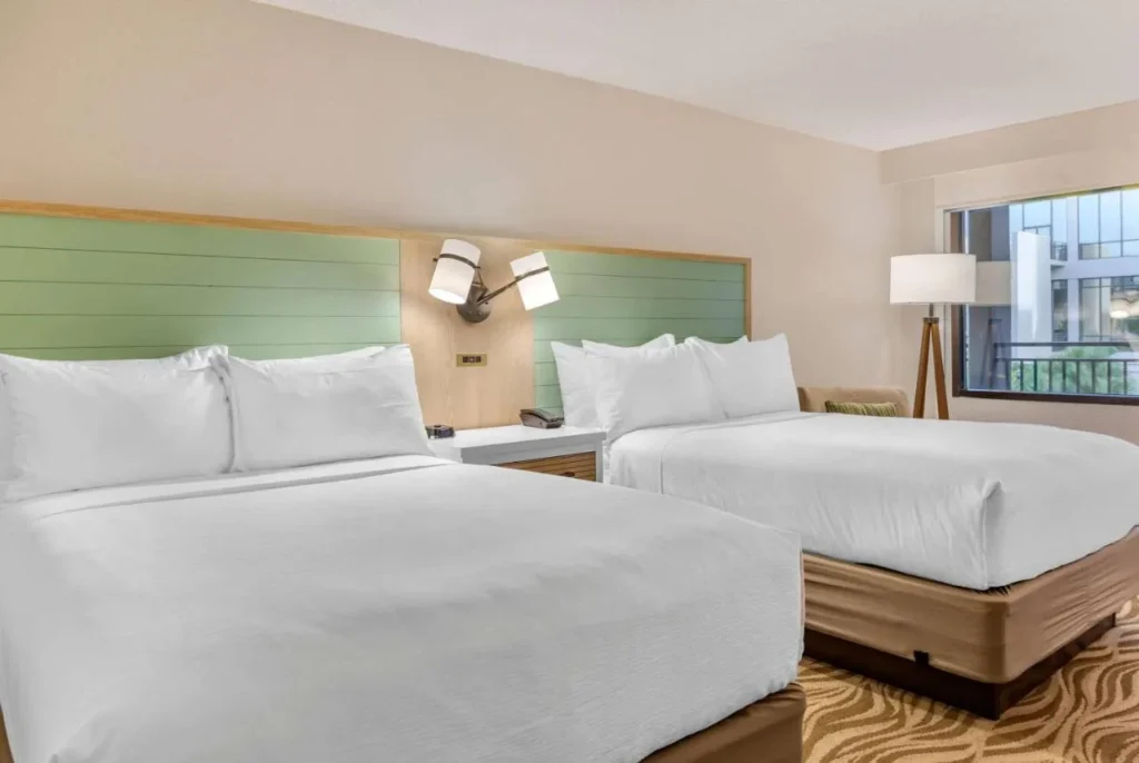 Room with two beds, green wood headboards and a window at Wyndham Garden Lake Buena Vista
