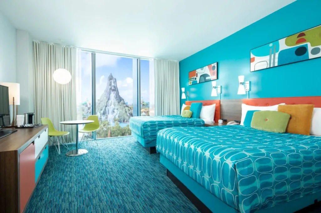 Room with two beds, turquoise walls and window facing Volcano Bay, Universal's Cabana Bay Beach Resort