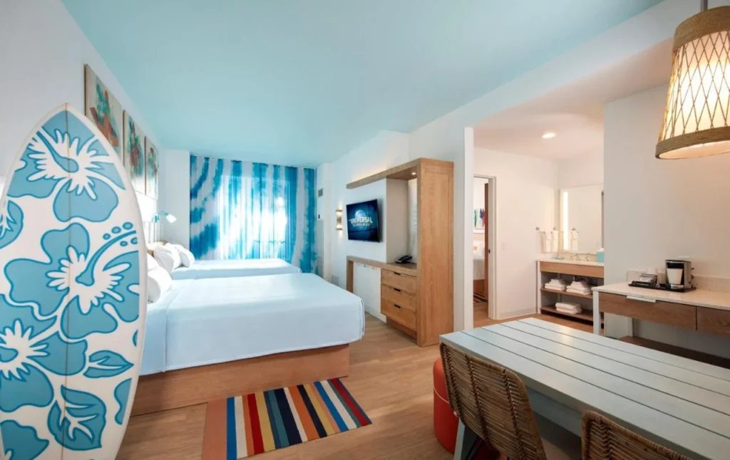 Room with two queen beds, a surfboard and a dining table at Endless Summer Resort Surfside