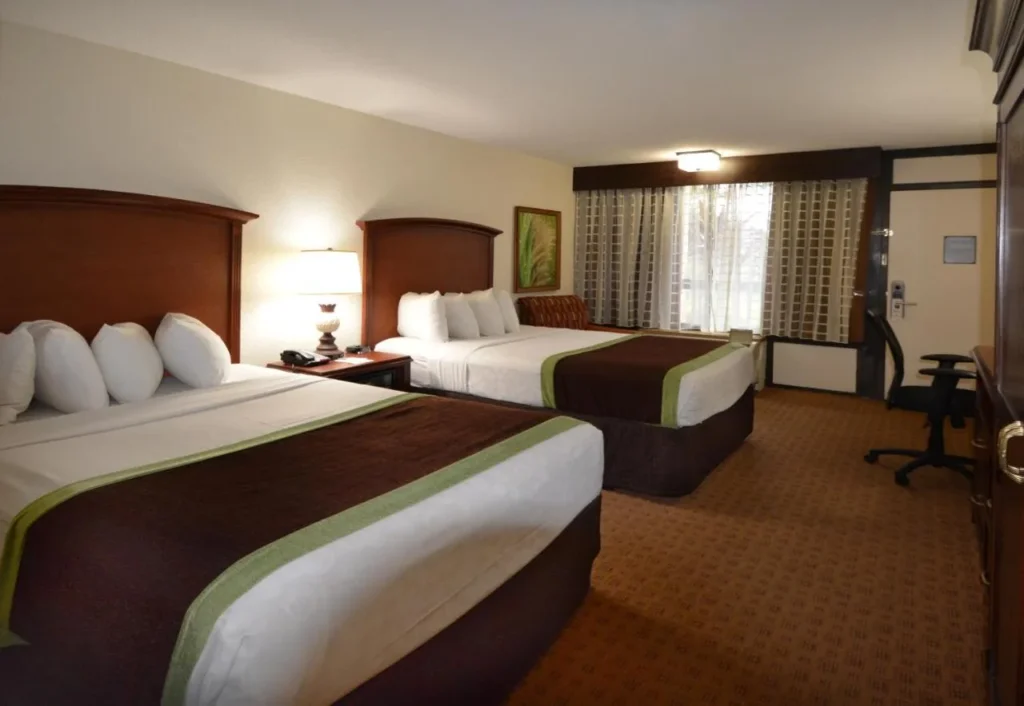 Habitaci&oacute;n con dos camas queen y una ventana con cortinas, Rosen Inn Lake Buena Vista