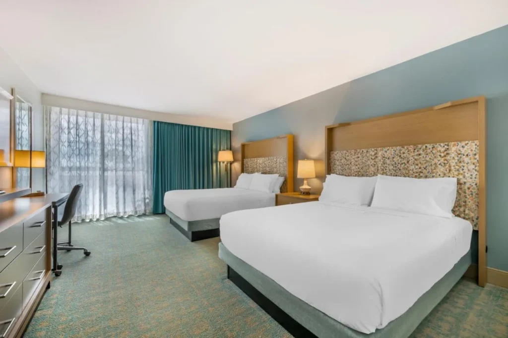 Habitaci&oacute;n con dos camas queen y un escritorio en Holiday Inn Orlando Disney Springs &Aacute;rea