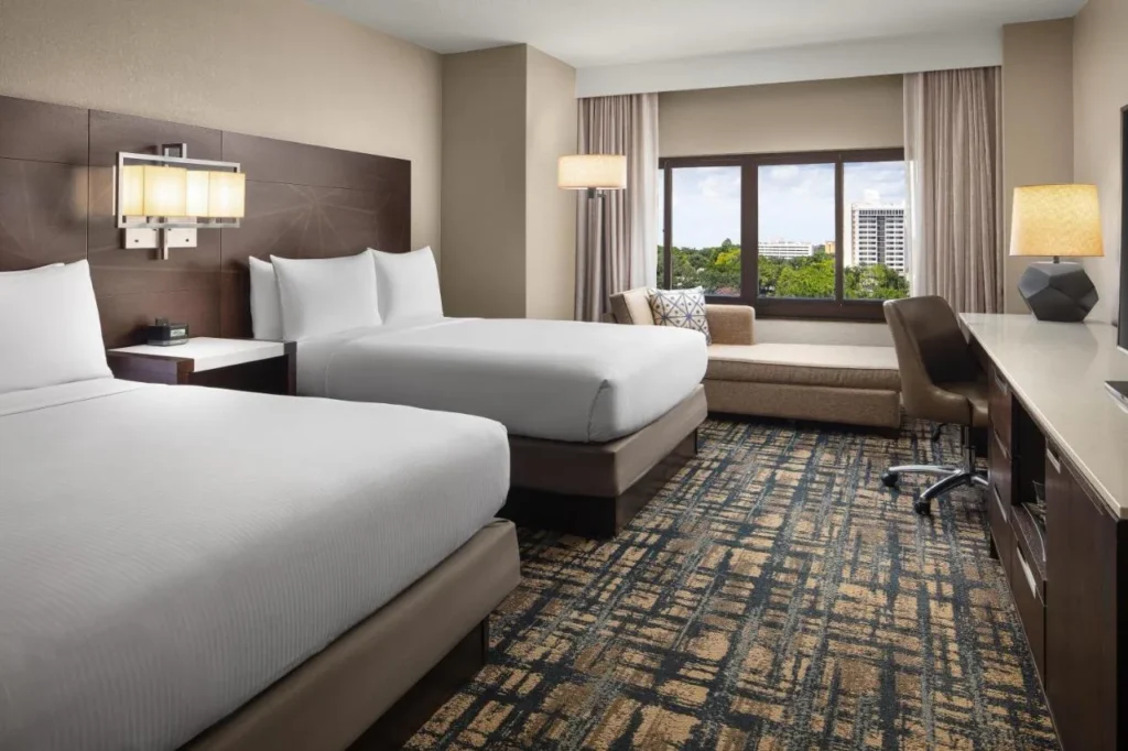 Room with two queen beds and a window seat at Hilton Orlando Lake Buena Vista