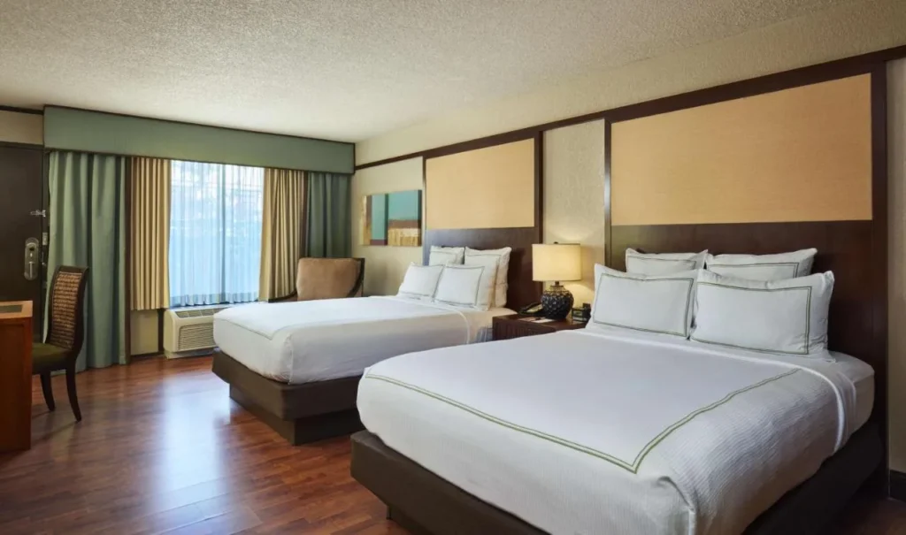 Room with two queen beds and wood floors at the DoubleTree Orlando Theme Park Resort