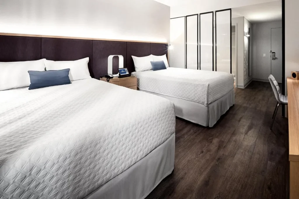 Room with two queen beds and wood-look floors at Universal Aventura Hotel