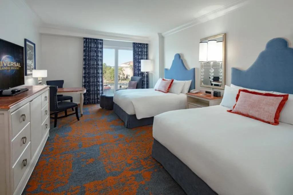 Habitación con dos camas queen, cabeceros azules y cómoda en Loews Portofino Bay Hotel