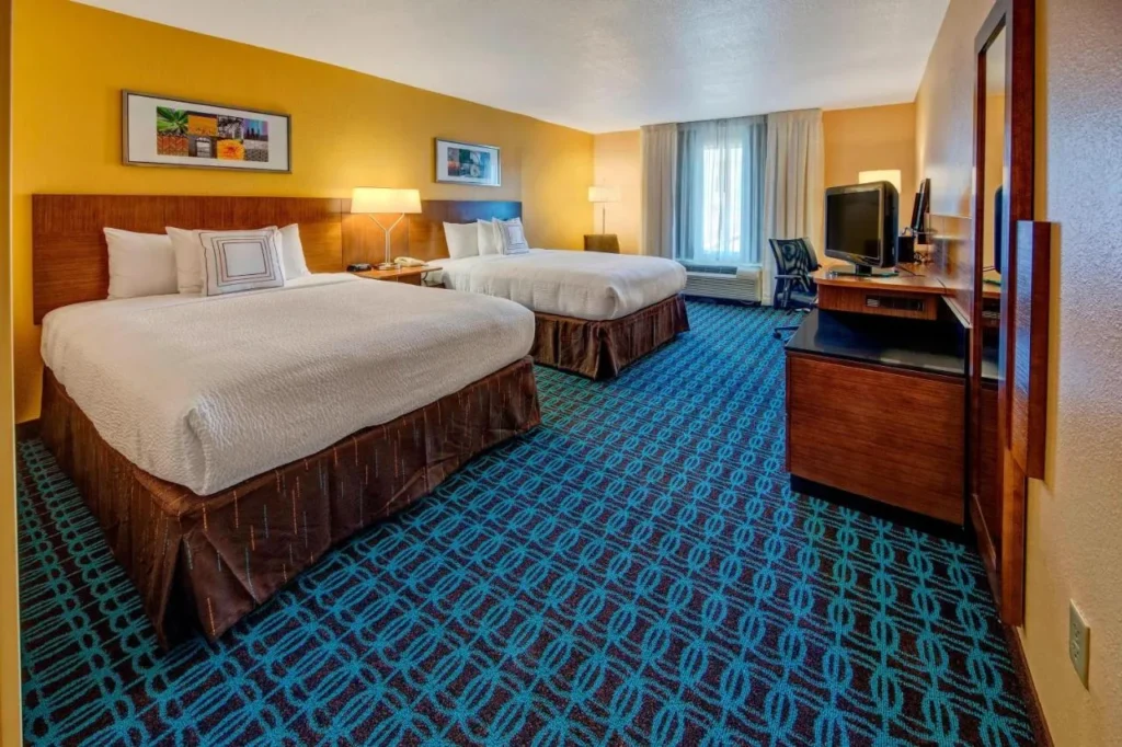 Room with two queen beds, desk and TV at Fairfield Inn & Suites Near Universal