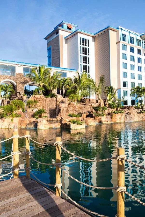 Rope-lined dock on the lagoon below rockwork and a guest tower at Loews Sapphire Falls Resort