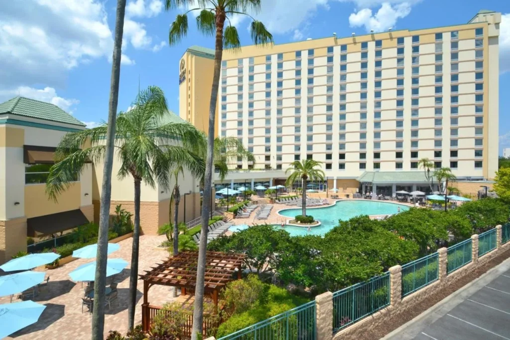 Rosen Plaza Hotel torre por encima de su piscina al aire libre con sombra de palma y patio en International Drive