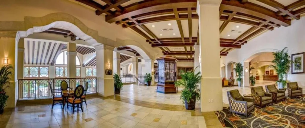 Vest&iacute;bulo Rosen Shingle Creek con columnas arqueadas, techos con vigas y zonas de estar sill&oacute;n