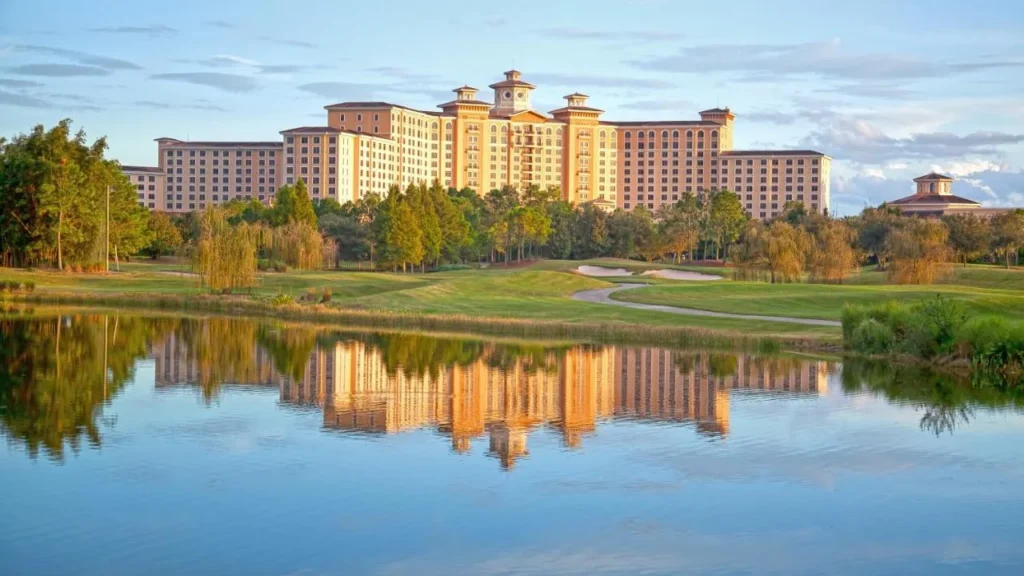 Rosen Shingle Creek complejo edificio reflejado en un estanque de campo de golf al atardecer