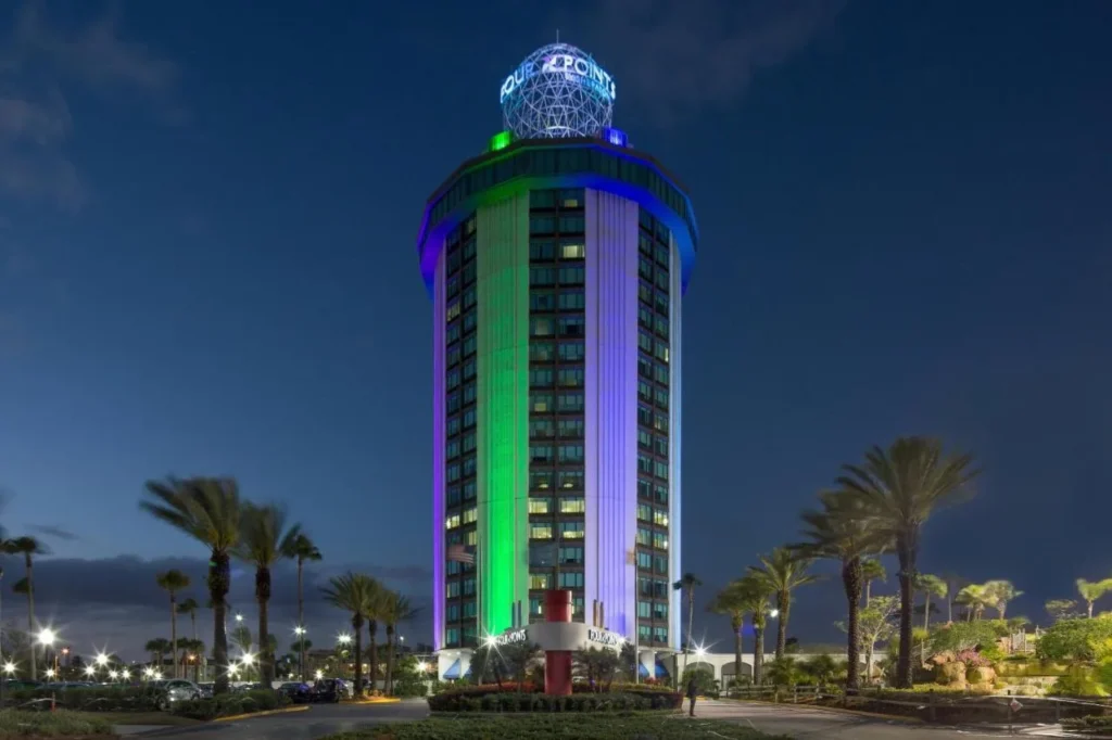 Round Four Points by Sheraton Orlando International Drive tower lit green and purple at night