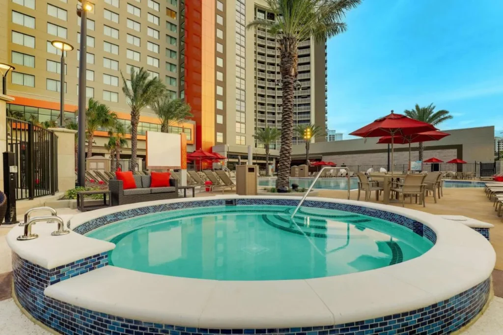 Round hot tub beside the pool deck below the towers of Drury Plaza Hotel Orlando