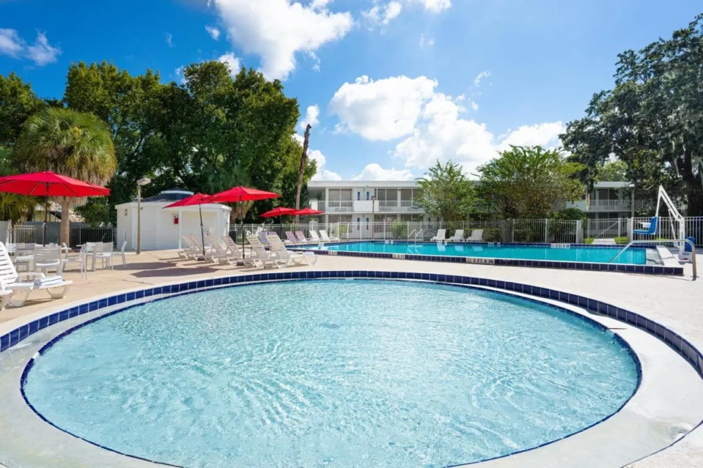 Piscina redonda para ni&ntilde;os y piscina principal con sombrillas rojas en Baymont Lake Buena Vista South