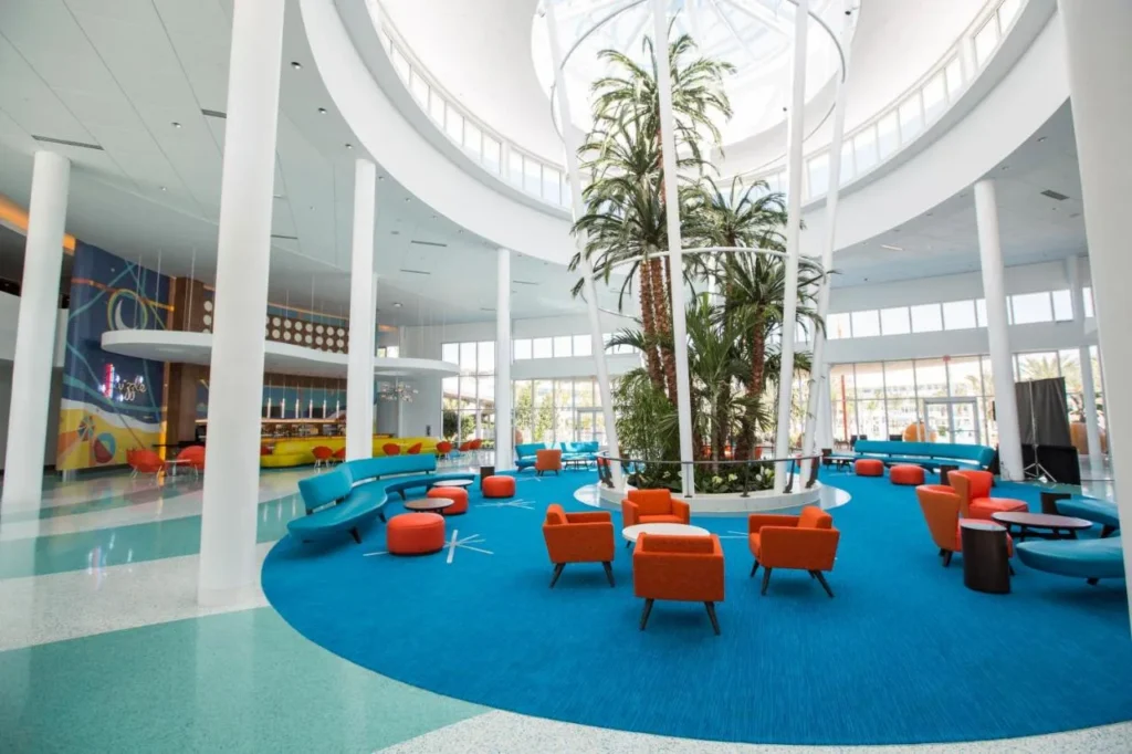 Round lobby with indoor palms, a skylight and orange armchairs at Cabana Bay Beach Resort