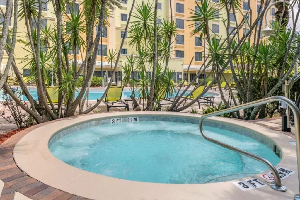Ba&ntilde;era de hidromasaje exterior redonda junto a la piscina y la torre en Comfort Suites Maingate East