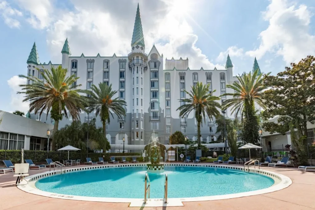 Round outdoor pool with fountain in front of the spired Castle Hotel, Autograph Collection in Orlando