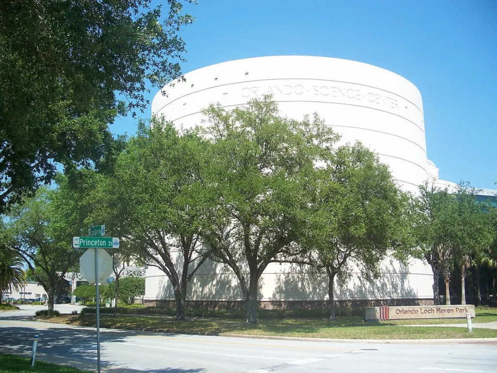 Round white Orlando Science Center building behind oak trees at Princeton Street in Loch Haven Park