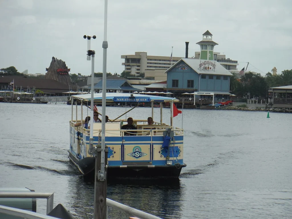 Saratoga Queen water taxi crossing the lake at Disney Springs with The BOATHOUSE behind