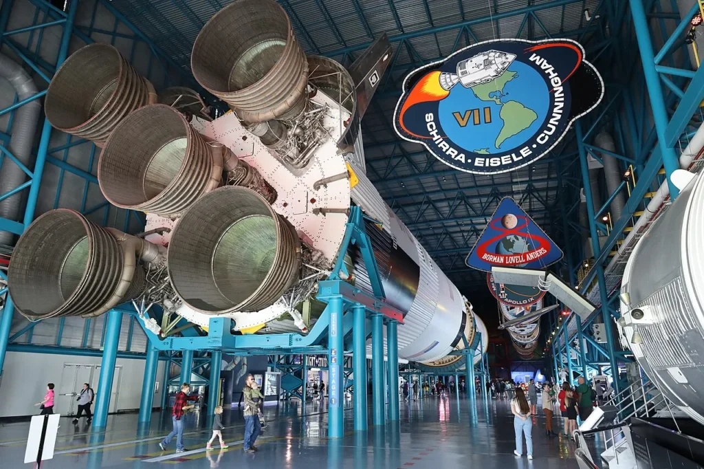 Cohete Saturno V mostrado horizontalmente con parches de misión dentro del Centro Apolo/Saturno V, Kennedy Space Center