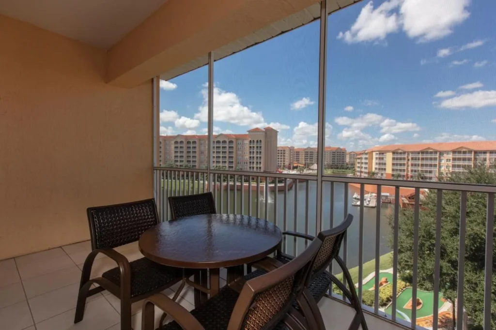 Screened balcony with dining set overlooking the lake and mini golf at Westgate Town Center Resort