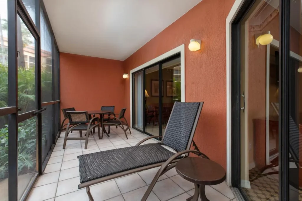 Screened patio with a lounger and dining set outside a Westgate Lakes villa