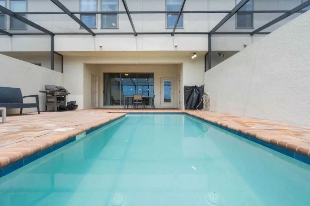 Piscina privada y patio detrás de una casa adosada en Windsor en Westside en Kissimmee