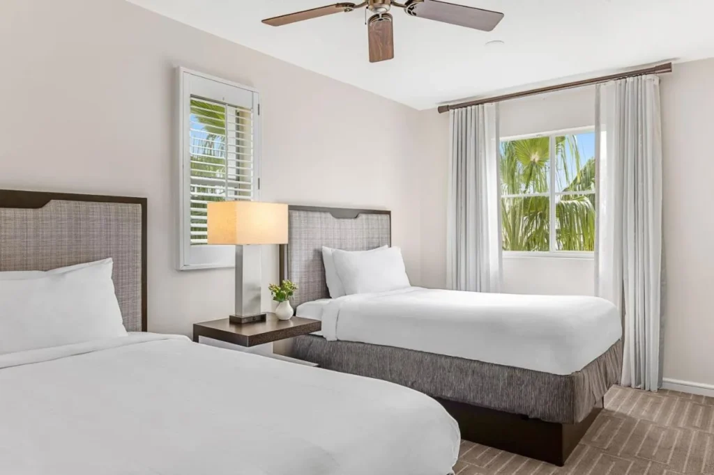 Segundo dormitorio con dos camas y persianas de plantación en una villa en Marriott's Grande Vista