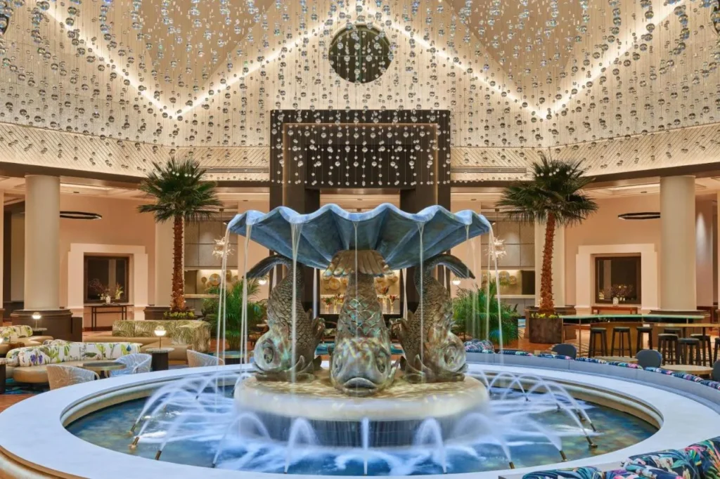 Shell-shaped dolphin fountain under a crystal-strand ceiling in the Walt Disney World Dolphin lobby