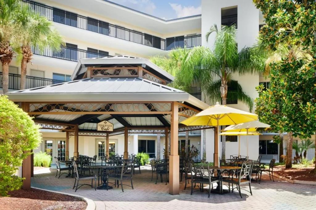 Sidewalk Cafe gazebo and umbrella tables in the courtyard at Staybridge Suites Orlando Royale Parc