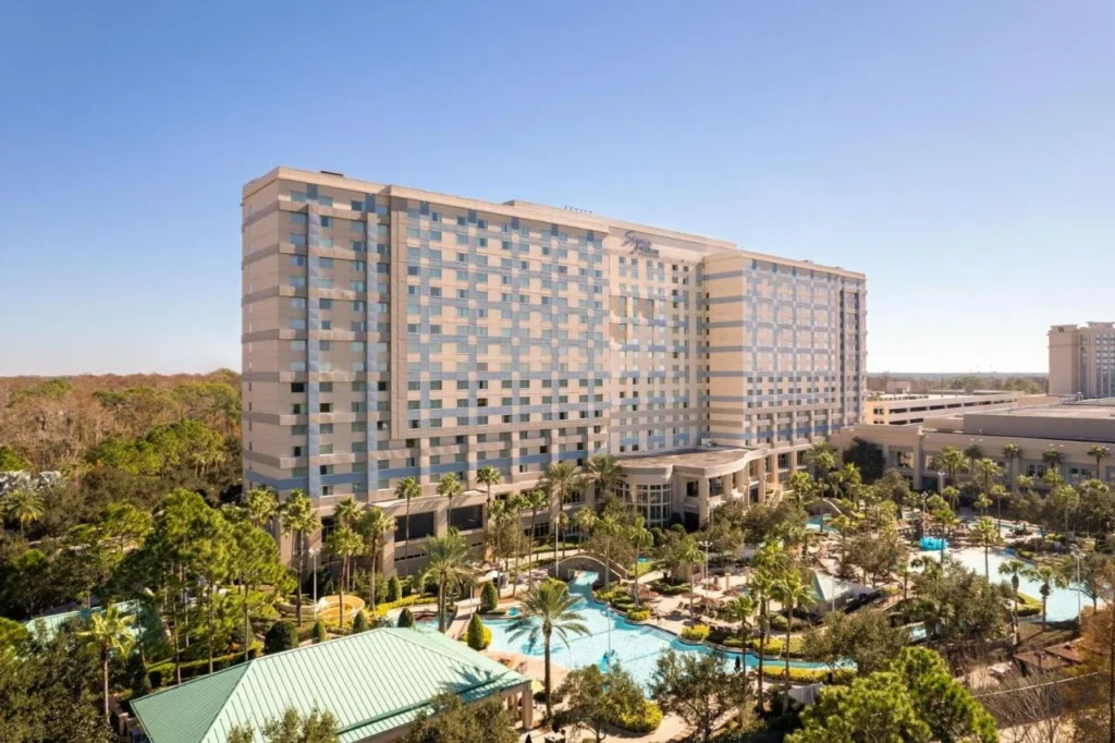 Signia by Hilton Orlando Bonnet Creek tower above its palm-lined pool complex