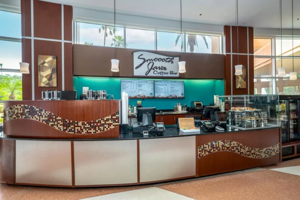 Barra de café Smoooth Java con caso de pastelería y ventanas con vista a la palma en Rosen Centre Hotel