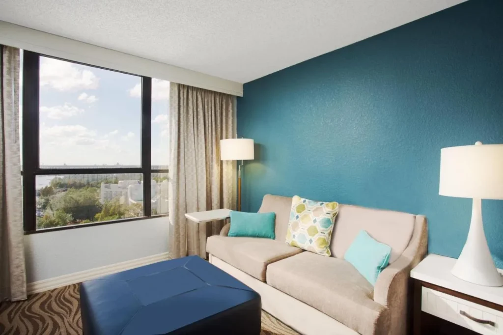 Sofa seating area with a teal wall and window view at Wyndham Lake Buena Vista