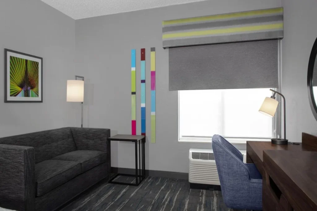 Sofa, side table and desk by the window in a Hampton Inn Orlando/Lake Buena Vista room