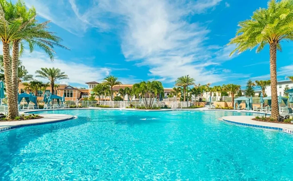Solara Resort casa club con palmeras, cabañas y el edificio de la casa club detrás