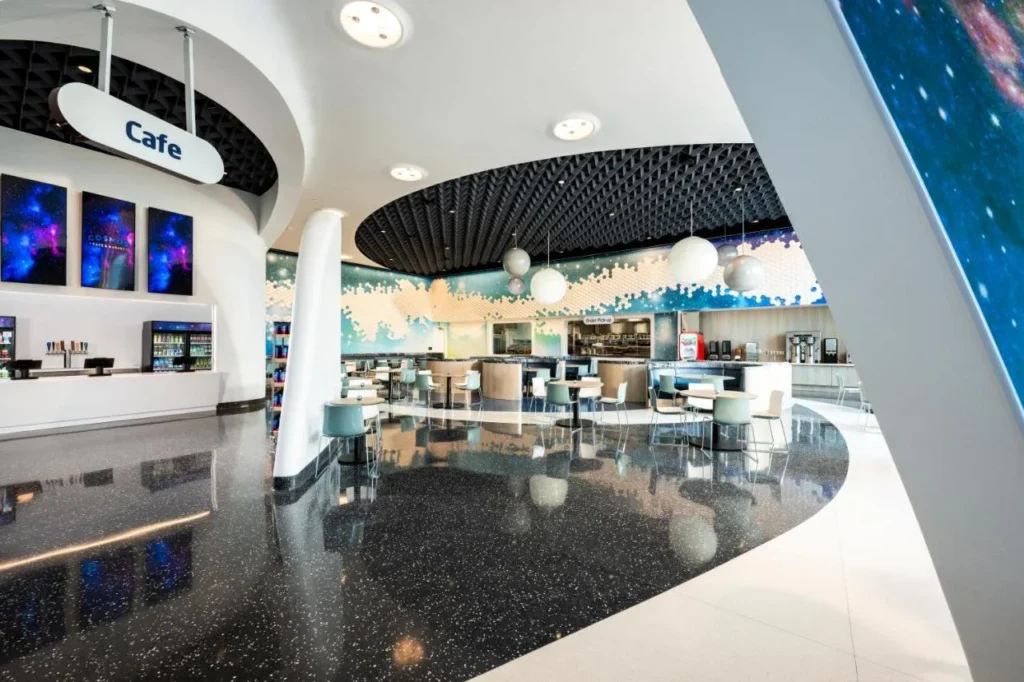 Café de temática espacial con asientos y arte de la pared de la galaxia en Universal Stella Nova Resort