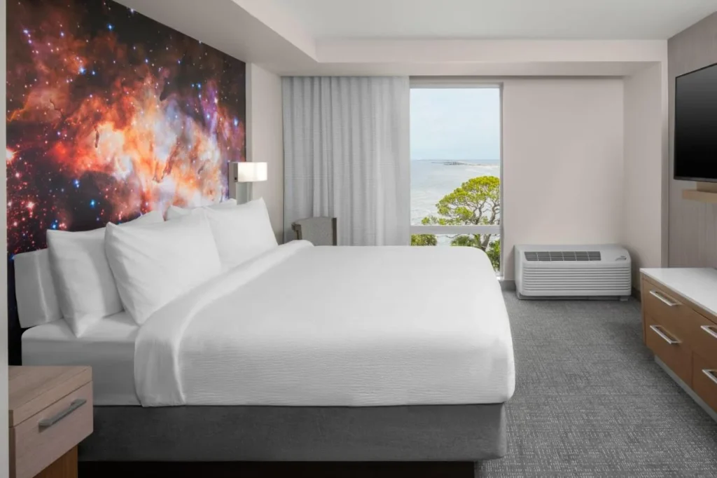 Habitación temática espacial con cama king, mural de nebulosa y vista al río en Courtyard Titusville Kennedy Space Center