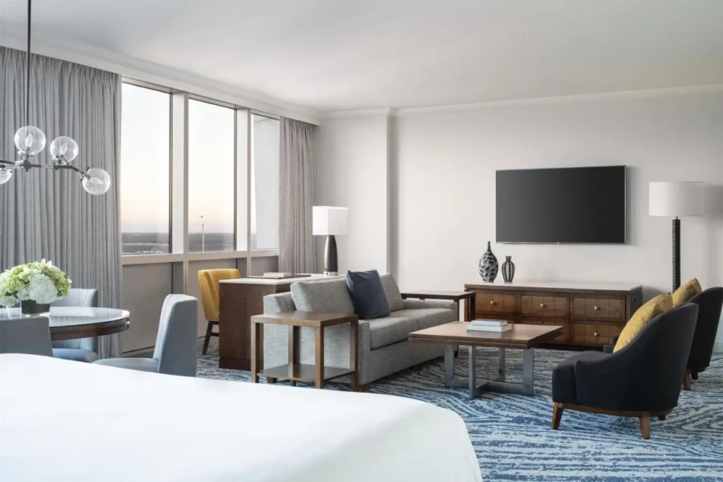 Amplia habitaci&oacute;n con cama, sof&aacute;, sillones, mesa redonda y TV de pared en Hyatt Regency Orlando