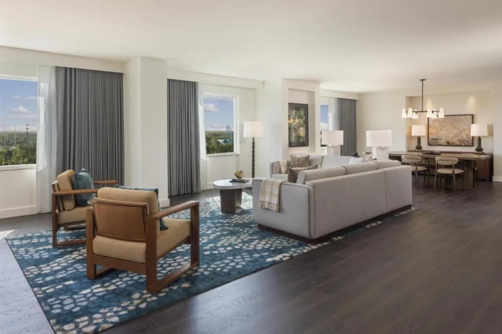 Spacious suite living room with sofa, armchairs and a dining table at Hilton Orlando